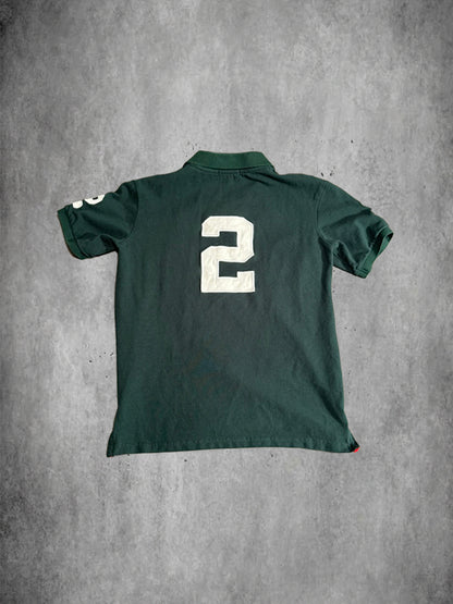 Green polo shirt with number 2 on the back against a gray concrete background